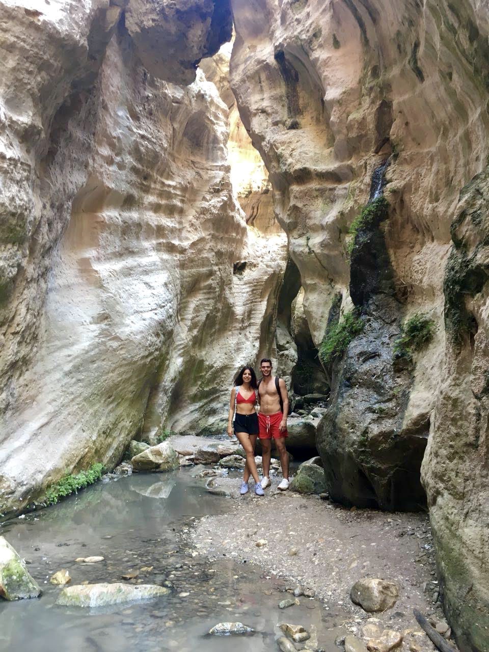 Couple standing inside a dramatic narrow canyon gorge
